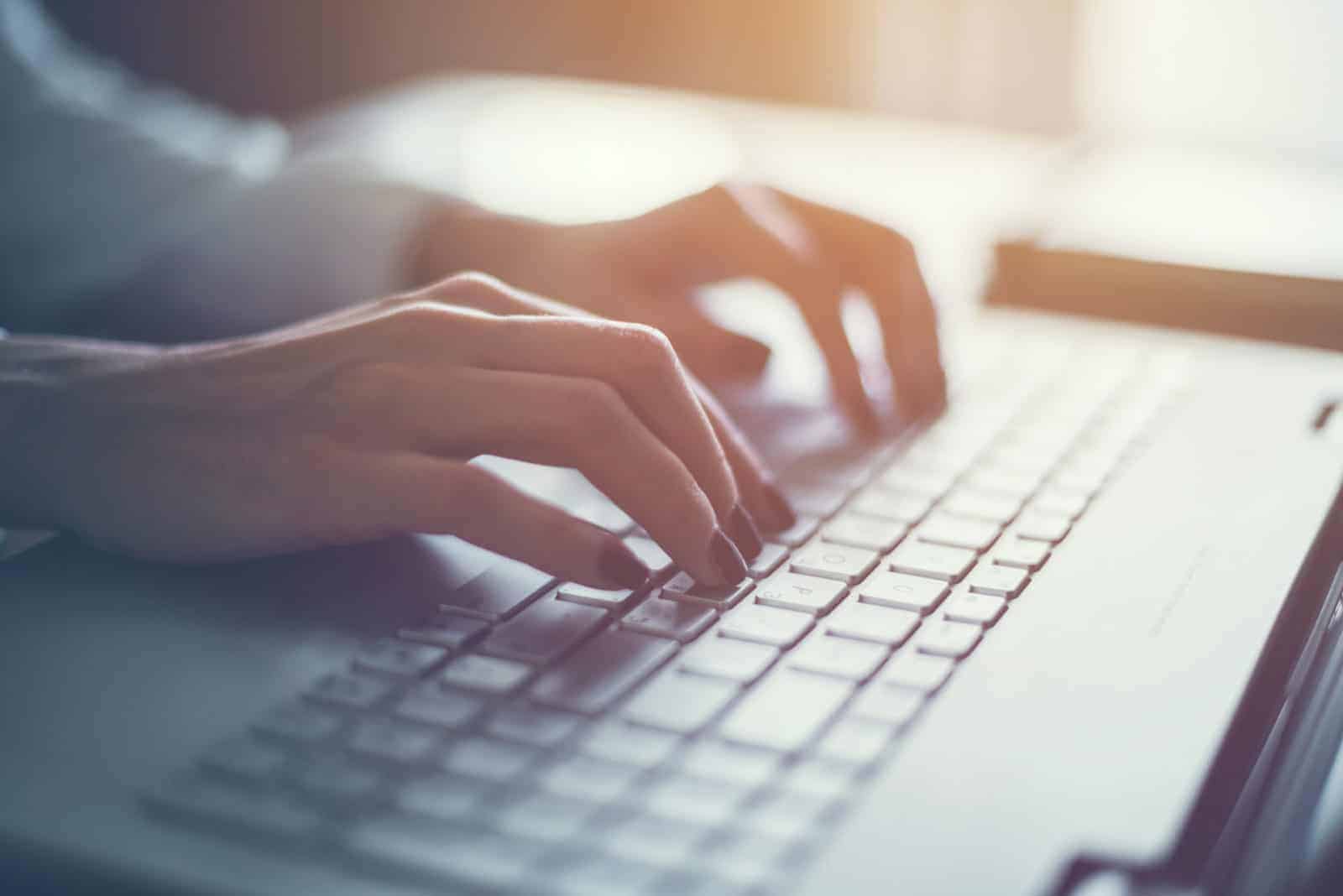 An IT professional typing at a keyboard while reviewing a website